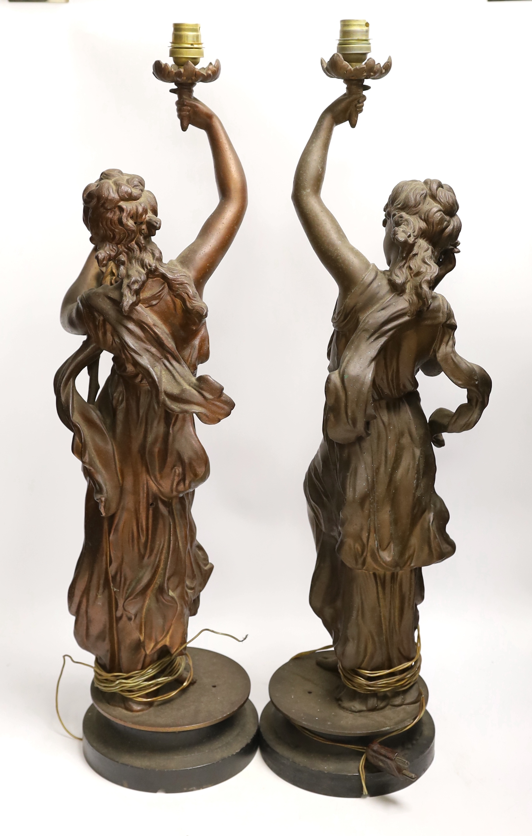 A pair of patinated spelter figural lamp bases, 63cm high not including light fitting